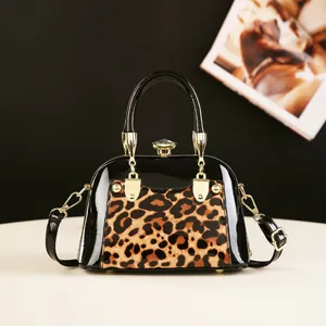 Detailed view of leopard print handbag with glossy patent leather and crystal clasp