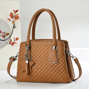 Close-up of brown quilted leather handbag with diamond stitching and star charm detail