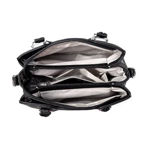 Vue intérieure du sac noir montrant trois compartiments et une doublure à motifs gris