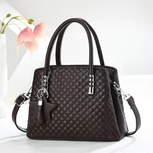 Detailansicht einer dunkelbraunen Stepptasche mit Sternanhänger und Gurtband