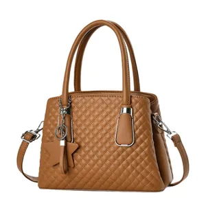 Caramel brown quilted leather handbag with twin handles and star charm accessory