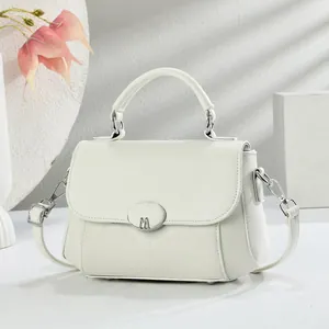 Minimalistische beige crossbodytas met zilveren M-gesp en handvat voor dames