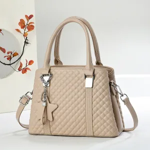 Dettaglio borsa trapuntata beige con ciondolo a stella e finiture in metallo argento