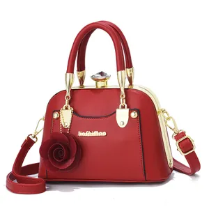 Red leather shell bag with gold metal frame, diamond clasp and rose charm detail