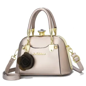 Detail of champagne gold leopard shell bag with diamond clasp and flower charm