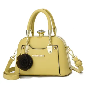 Detail of light yellow leopard-print shell bag with gold hardware and rose charm