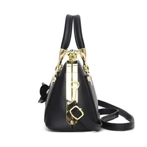 Black mini shell bag with gold hardware, floral charm and crystal clasp in side view
