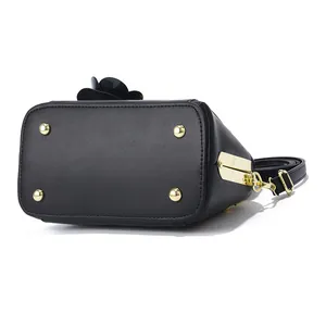 Mini structured black leather shell bag with gold hardware and floral top detail