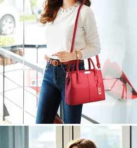 Dettaglio di una borsa in pelle rossa con trama litchi, finiture argento e tracolla rimovibile
