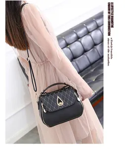 Detail of black quilted PU leather handbag with teardrop twist lock and metal zipper