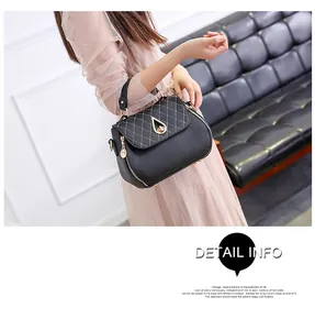 Detail of black lychee leather handbag featuring diamond quilting and gold lock closure