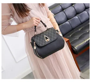 Detail of black PU leather bag with diamond quilting and gold teardrop twist lock