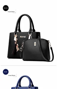 Detailansicht der schwarzen und blauen Ledertaschen mit Katzenanhänger und Quasten