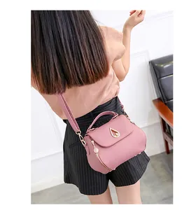 Detail shot of a stylish quilted pink PU leather crossbody bag worn by a model
