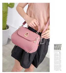 Detail of pink quilted PU leather handbag featuring a teardrop metal twist lock closure