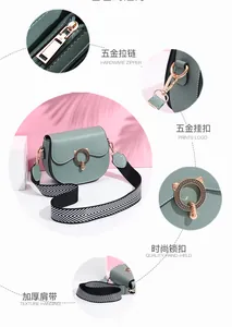Detail of dark green saddle bag with golden hardware and wide chevron fabric strap