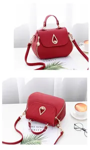 Detail of red litchi texture PU leather bag with teardrop metal buckle and quilted flap