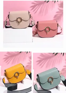 Detail view of multi-color saddle bags with wide straps and cat-shaped gold buckles