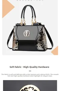 Detail of floral embroidery and gold metal logo on black patent leather handbag