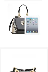 Detail view of glossy black patent leather bag with gold floral embroidery and iPad size scale
