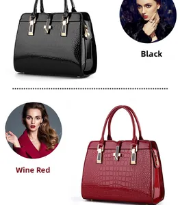 Close-up of black and burgundy crocodile embossed patent leather tote bag with gold buckle