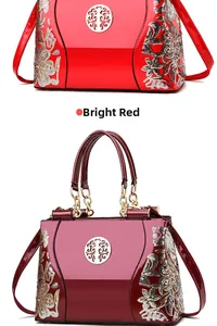 Close-up of red patent leather handbags featuring golden floral embroidery and metal buckle