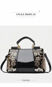 Detail of glossy black patent leather handbag with floral sequin embroidery and gold hardware