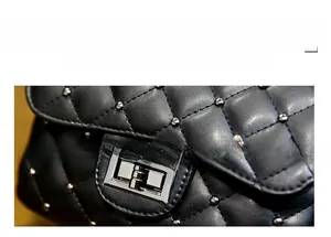 Detail of black quilted leather with metal rivet studs and silver rotary turn-lock