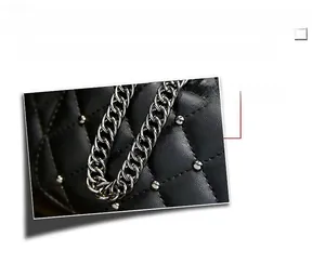 Detail of silver hardware chain and quilted PU leather on black crossbody bag