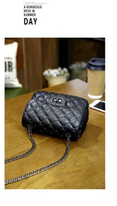 Detail of black quilted crossbody bag with silver studs and metal twist lock closure