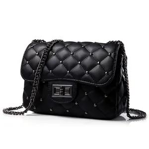 Black quilted crossbody bag with metal studs and chain strap on white background