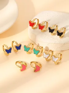 Vue détaillée de boucles d'oreilles papillon en sept couleurs avec bords perlés dorés