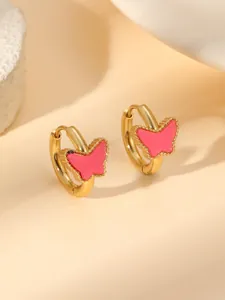 Détail de boucles d'oreilles papillon dorées avec émail rose et bordure perlée