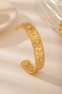 Dettaglio del bracciale rigido placcato oro 18 carati con trama martellata e bordo perlato