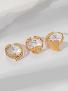 Detailed view of three 18k gold-plated rings with Roman numerals and heart design