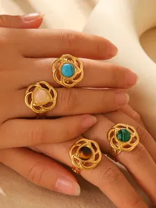 Detailed view of four 18k gold plated spiral rings set with colorful turquoise and resins