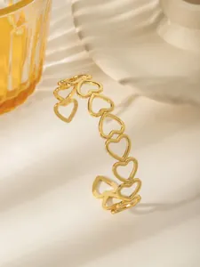 Dettaglio del bracciale aperto placcato oro 18 carati con motivi a cuore traforati