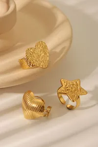 Detailed view of three golden textured rings with heart and star motifs on ceramics