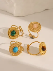 Close-up of vintage gold-plated rings with turquoise and malachite gemstone inlay