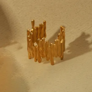 Macro detail of 18k gold plated open ring with modern molten irregular texture
