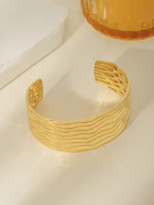 Dettaglio del bracciale aperto placcato oro 18k con trama a onde d'acqua orizzontale