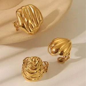 Detail of three gold rings featuring organic lava textures and shell-inspired patterns