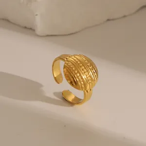 Macro detail of gold open ring featuring triple row embossed texture on polished steel
