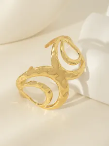 Dettaglio di bracciale rigido placcato oro 18k con trama martellata e design traforato