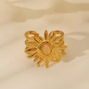 Detail of 18k gold sunburst ring with oval gemstone and intricate layered band