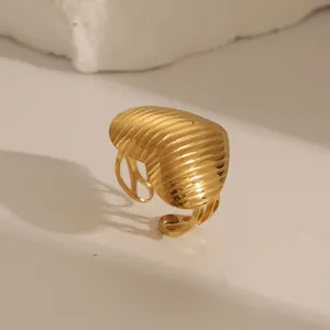 Detail of golden heart ring with textured 3D ridges and adjustable open band design