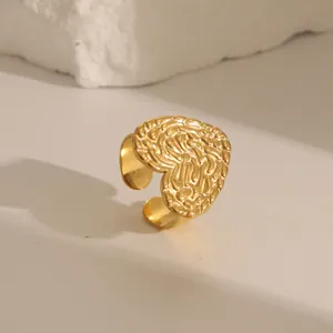 Detail of adjustable golden ring with textured heart shape and rustic lava surface finish