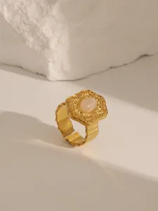 Detailed close-up of a floral 18K gold plated ring with a pink oval gemstone