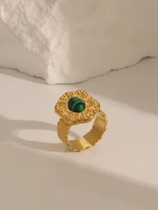 Detailed view of an 18K gold plated ring featuring a green turquoise and retro engraving