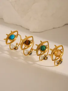 Macro detail of 18k gold plated open rings with turquoise and eye-shaped design